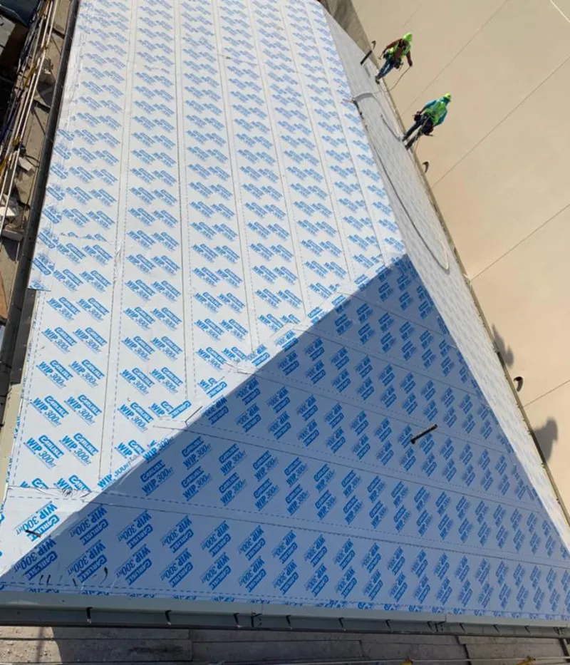 Professional roofers installing underlayment on a metal roof in Carrboro